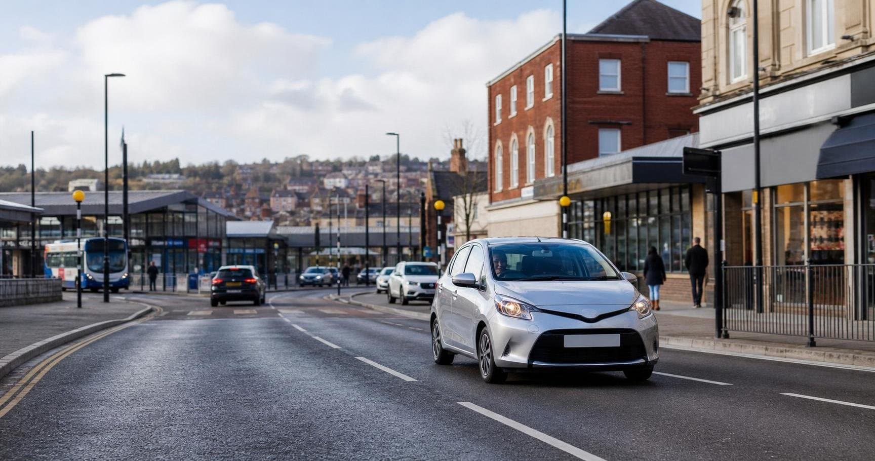 Compact hire car on a main road through Stocksbridge